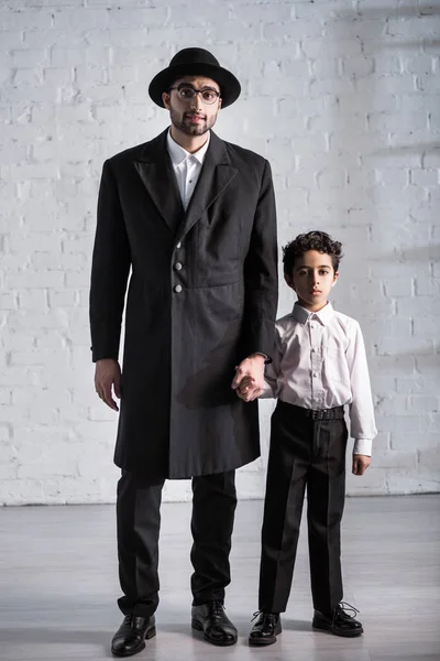 Handsome jewish father and cute son holding hands — Stock Photo