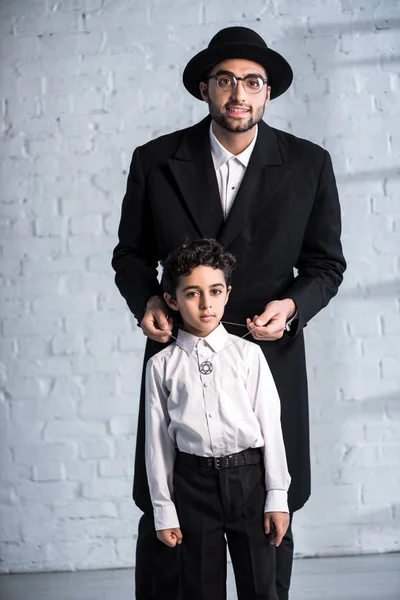Smiling jewish father wearing star of david necklace on son — Stock Photo