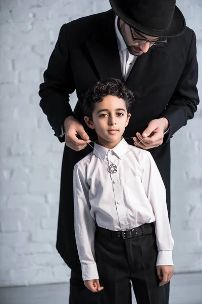 Handsome jewish father wearing star of david necklace on son — Stock Photo