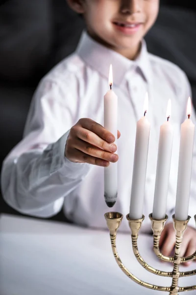 Abgeschnittene Ansicht eines lächelnden jüdischen Jungen im Hemd mit Kerze — Stockfoto