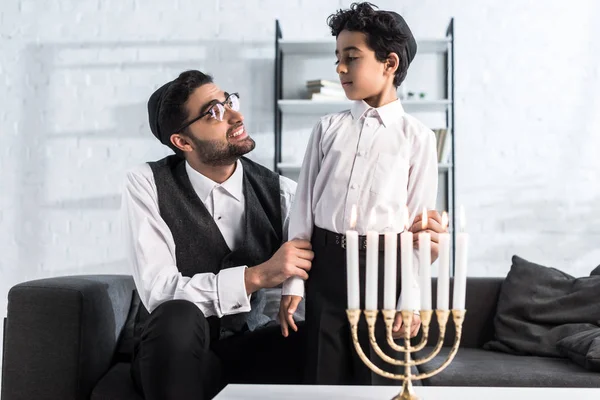 Lächelnder jüdischer Vater schaut niedlichen Sohn in Wohnung an — Stockfoto