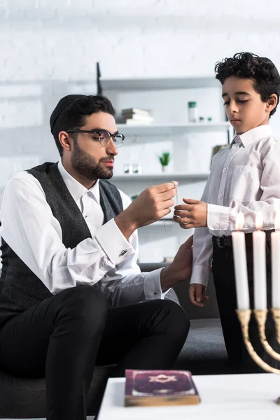 Jewish father giving necklace to cute son in apartment — Stock Photo