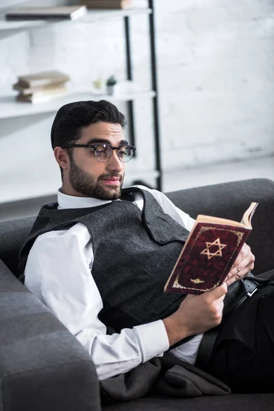 Handsome and young jewish man in glasses reading tanakh — Stock Photo