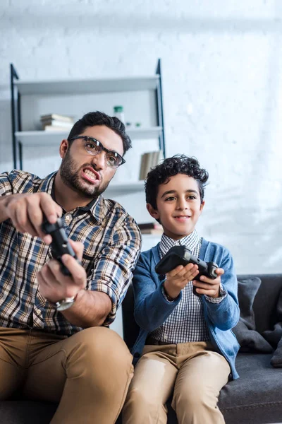 KYIV, UKRAINE - 15 OCTOBRE 2019 : Père juif et fils souriant jouant à un jeu vidéo — Photo de stock