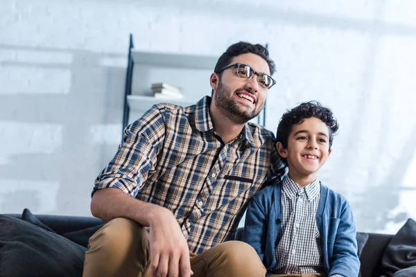 Smiling jewish father and son watching tv in apartment — Stock Photo