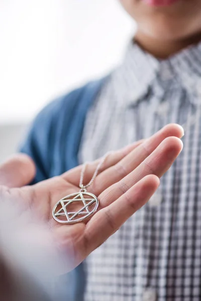 Cropped view of jewish father holding star of david necklace on son — Stock Photo