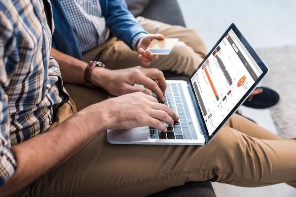 KYIV, UKRAINE - OCTOBER 15, 2019: cropped view of jewish father using laptop with soundcloud website and son holding credit card — Stock Photo