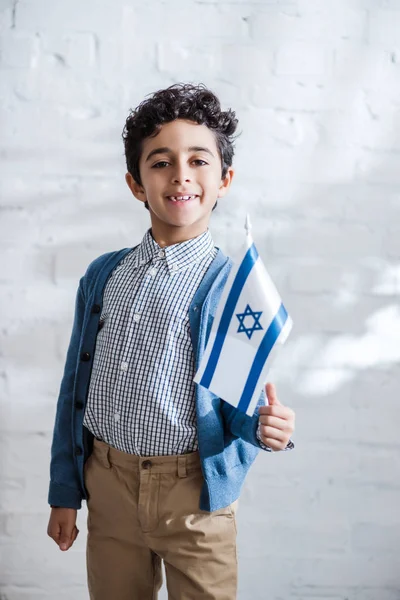 Smiling and cute jewish boy holding flag of israel — Stock Photo