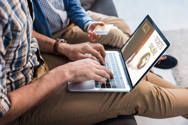 Visão cortada do pai judeu usando laptop com bilhetes site on-line e filho segurando cartão de crédito — Fotografia de Stock