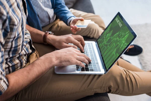 Visão cortada do pai judeu usando laptop com site de comércio on-line e filho segurando cartão de crédito — Fotografia de Stock