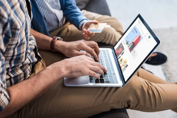 QUIIV, UCRÂNIA - OUTUBRO 15, 2019: visão recortada do pai judeu usando laptop com site do ebay e filho segurando cartão de crédito — Fotografia de Stock