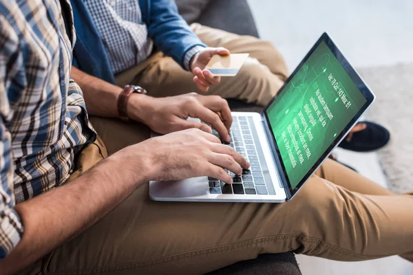 Cropped view of jewish father using laptop with medical website and son holding credit card — Stock Photo