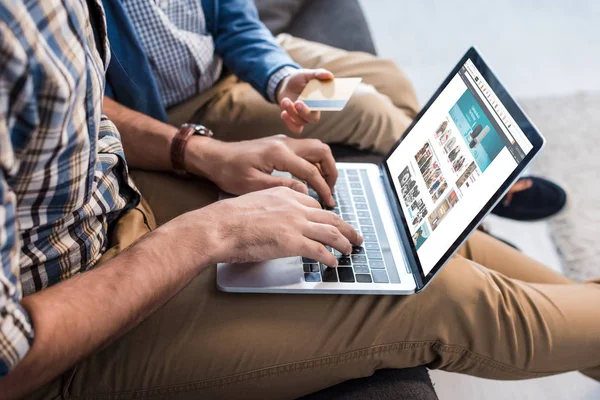 KYIV, UKRAINE - OCTOBER 15, 2019: cropped view of jewish father using laptop with bbc website near son holding credit card — Stock Photo