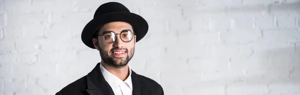 Prise de vue panoramique de l'homme juif souriant dans des lunettes regardant la caméra — Photo de stock