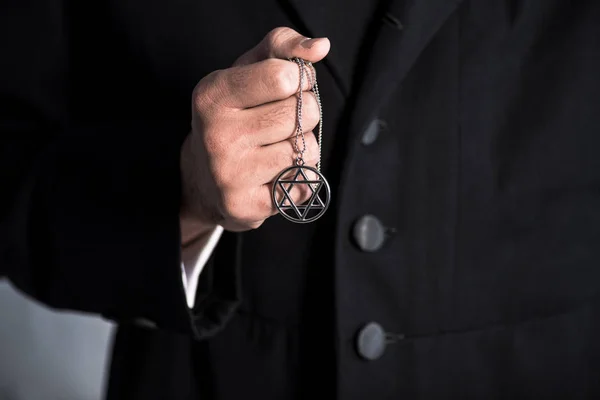 Cropped view of jewish man holding star of david necklace — Stock Photo
