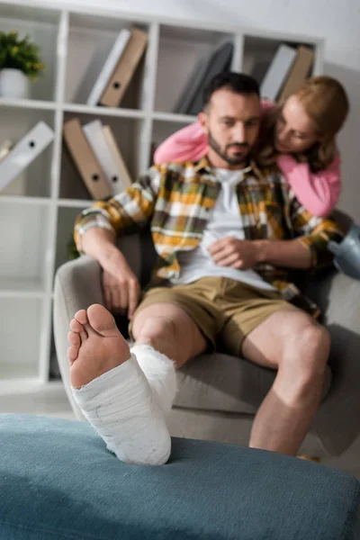 Verletzter Mann sitzt neben pflegender Freundin — Stockfoto