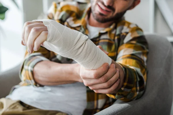 Foco seletivo do braço lesionado do homem barbudo em bandagem — Fotografia de Stock