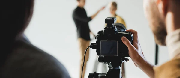 Panoramic shot of producer and photographer taking photo of model and hairstylist on backstage — Stock Photo