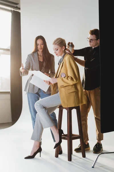 Producer talking with model and hairstylist doing hairstyle on backstage — Stock Photo