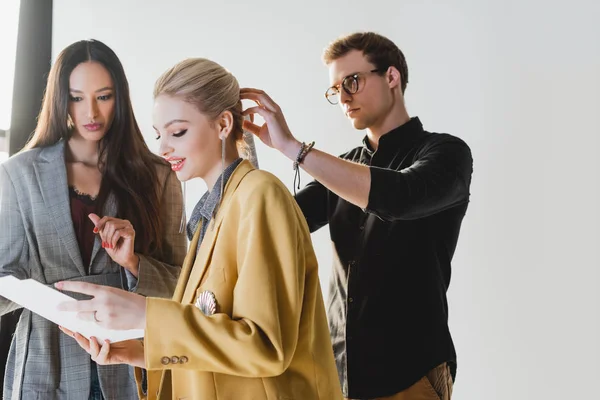 Producer talking with model and hairstylist doing hairstyle on backstage — Stock Photo