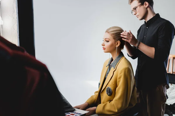 Side view of hairstylist doing hairstyle to stylish model on backstage — Stock Photo