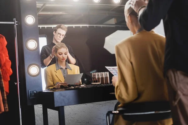 Foyer sélectif de coiffeur faisant coiffure au modèle élégant sur les coulisses — Photo de stock