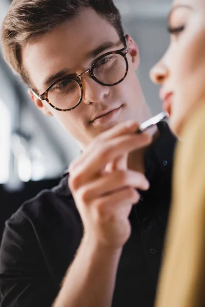 Selective focus of Makeup Artist doing makeup to model on backstage — Stock Photo