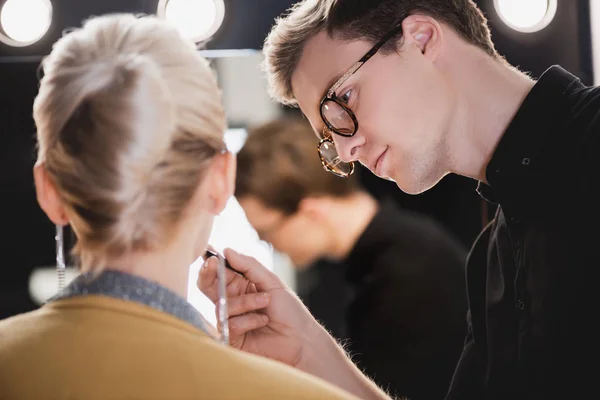 Selective focus of Makeup Artist doing makeup to model on backstage — Stock Photo