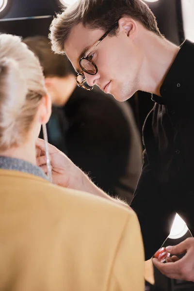 Selective focus of Makeup Artist doing makeup to model on backstage — Stock Photo