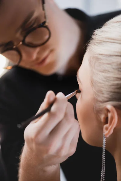 Selective focus of Makeup Artist doing makeup to model on backstage — Stock Photo