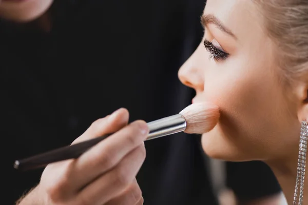 Vue recadrée de maquilleur faisant maquillage à modèle attrayant sur les coulisses — Photo de stock