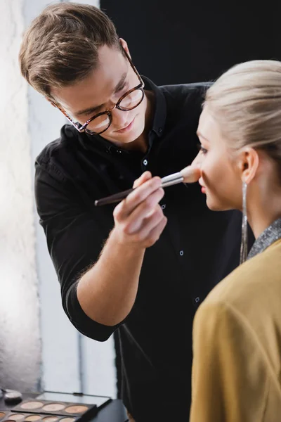Selective focus of Makeup Artist doing makeup to model on backstage — Stock Photo