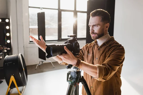 Angry photographer taking photo with digital camera on backstage — Stock Photo