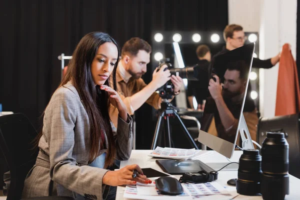 Selective focus of producer looking at references on background — Stock Photo