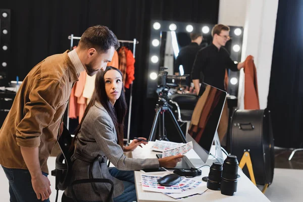 Selective focus of producer and photographer discussing references on backstage — Stock Photo