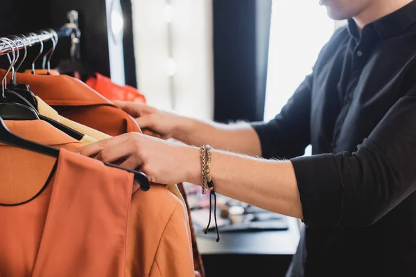 Cropped view of stylist choosing clothes for photo shoot on backstage — Stock Photo