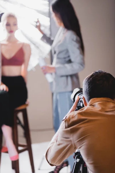 Foyer sélectif du photographe prenant la photo du modèle et coiffeur — Photo de stock