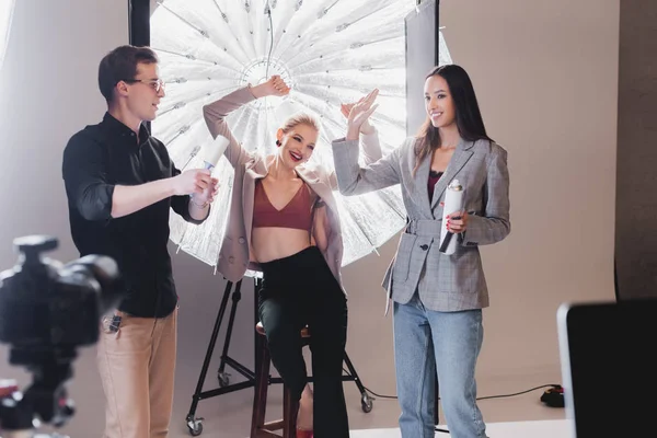 Enfoque selectivo de modelo sonriente, estilista, estilista mostrando sí gesto en el backstage - foto de stock