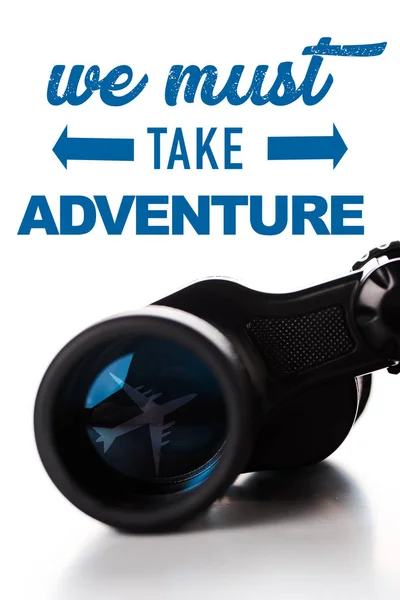 Close up of black binoculars near we must take adventure letters on white — Stock Photo