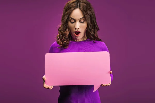 Mulher surpreso segurando bolha de fala no fundo roxo — Fotografia de Stock