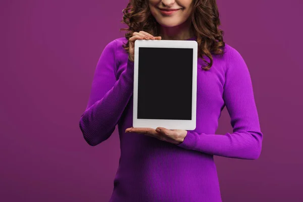 Vue recadrée de la femme souriante tenant tablette numérique avec écran blanc sur fond violet — Photo de stock