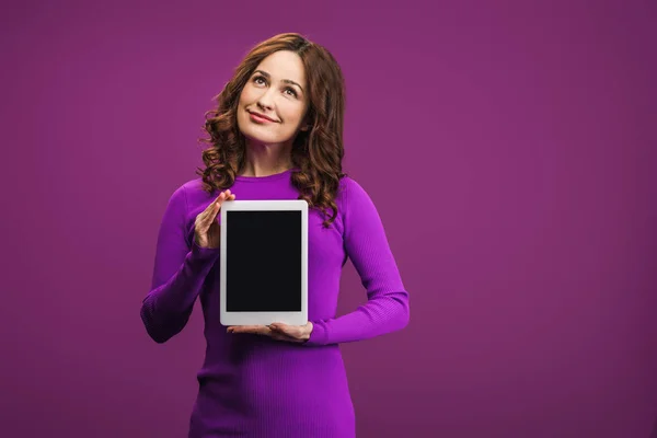 Mulher sorrindo segurando tablet digital com tela em branco no fundo roxo — Fotografia de Stock