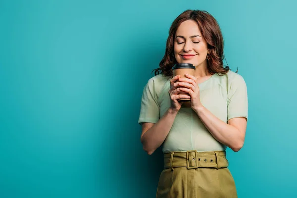 Souriant, heureux fille tenant café pour aller sur fond bleu — Photo de stock