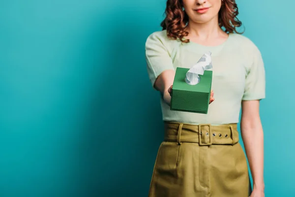 Cropped view of sad woman holding paper napkins on blue background — Stock Photo