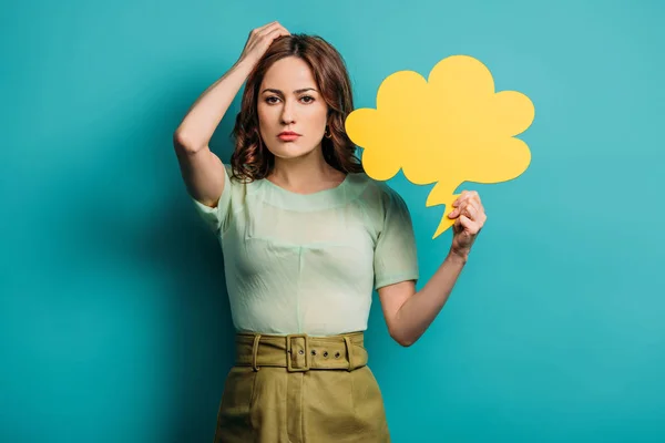Thoughtful woman touching head while holding thought bubble on blue background — Stock Photo