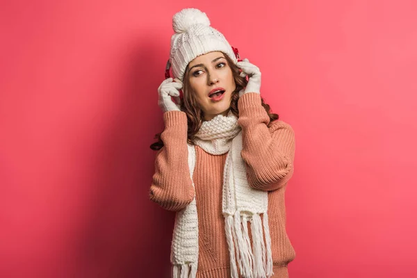 Dreamy girl listening music in wireless headphones on pink background — Stock Photo