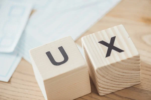 Foco seletivo de cubos com letras ux e layouts na mesa — Fotografia de Stock