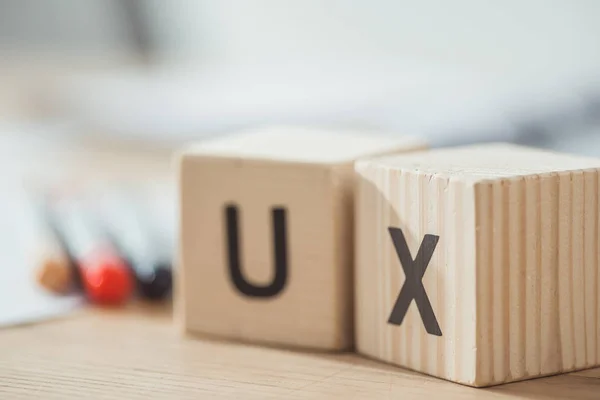 Concentration sélective de cubes en bois avec des lettres ux sur la table — Photo de stock
