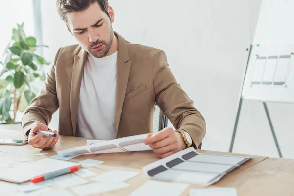 Handsome ux diseñador que trabaja con plantillas de sitios web y diseños en el estudio de diseño - foto de stock