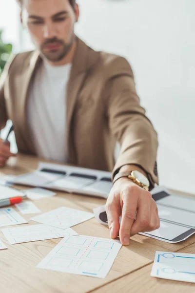 Enfoque selectivo del diseñador desarrollando diseños de plantillas y marcos para teléfonos móviles en la oficina - foto de stock